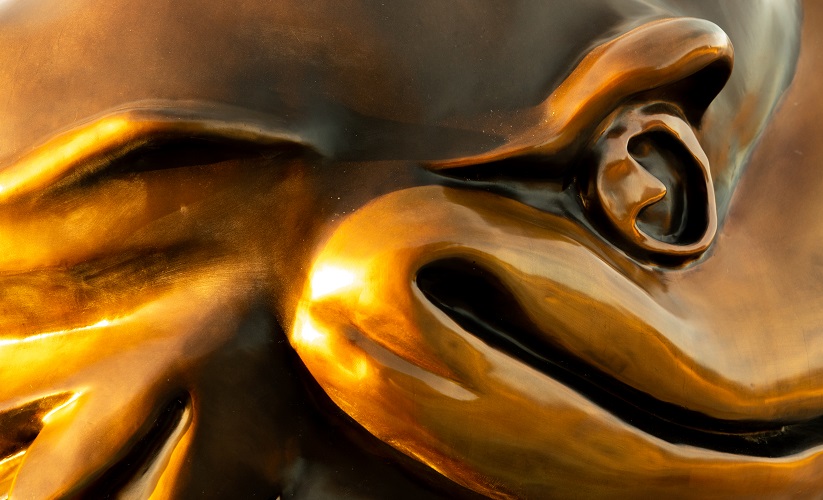 Closeup of a bronze Jayhawk statue, focusing on an eyes and mouth